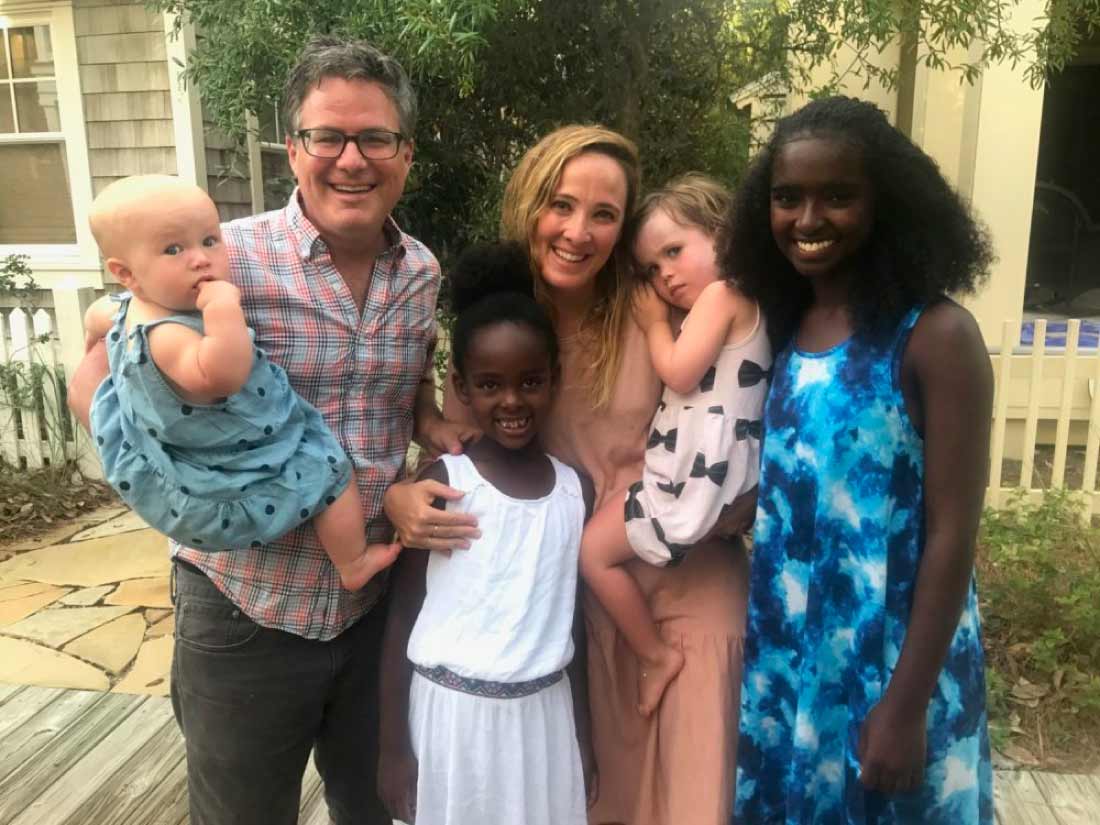 A family of six smiling together in their backyard